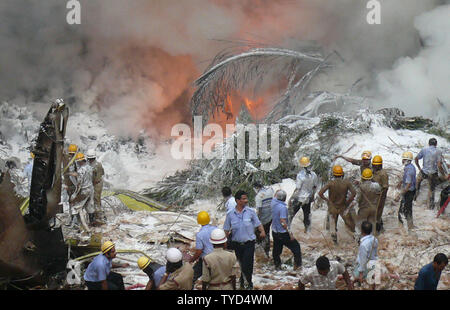 Feuerwehrmänner Begießen der Air India Express Ebene, nachdem der Start- und Landebahn hinausgeschossen und Bajpe Airport in Mangalore, Indien stürzte am 22. Mai 2010. Der 166 Passagiere und Besatzungsmitglieder an Bord, nur 8 überlebt. UPI Stockfoto