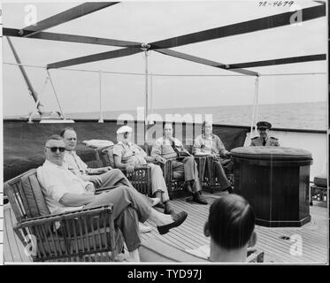 Foto von Präsident Truman und andere sich auf dem Achterdeck von seiner Yacht, die U.S.S. WILLIAMSBURG, während Ferien Kreuzfahrt von Washington nach Key West, Florida: (von links nach rechts) John R. Steelman, Assistent des Präsidenten; Charles Murphy, spezielle Berater des Präsidenten; Präsident Truman; Admiral Robert Dennison, Naval Berater des Präsidenten; Pressesprecher Charles Ross, Commander Donald MacDonald, kommandierender Offizier der Williamsburg. Stockfoto