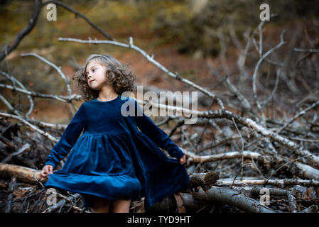 Stilvolle kind Mädchen 6-7 Jahre alt tragen Designer Blue Velvet Dress in Wald. Langsam tanzen. Kindheit. Stockfoto