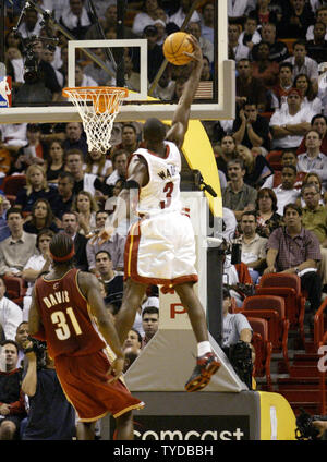 Miami Heats Dwyane Wade slams dieser Schuss als Cleveland Kavaliere Ricky Davis kann nur im zweiten Quartal NBA Action ansehen, in der American Airlines Arena, Miami, Florida, 12. November 2003. Die Hitze nahm den Gewinn 88-83 für den ersten Sieg der Saison. (UPI/Michael Busch) Stockfoto