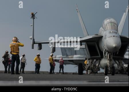 Philippinischen MEER (Nov. 2, 2016) Petty Officer 1st Class (AW/SW) Anthony Taylor, von Tampa, Florida, leitet eine F/A-18F Super Hornet, zugeordnet zu den "iamondbacks" von Strike Fighter Squadron (VFA) 102, auf dem Flugdeck der Marine nur Vorwärts - bereitgestellt Flugzeugträger USS Ronald Reagan (CVN 76), während der scharfen Schwert 17 (KS 17). KS 17 Eine Biennale ist, Vorsitzende des Generalstabs, US Pacific Command-gesponserten Bereich Training (Ftx). KS17 ist eine gemeinsame/bilaterale FTX konzipiert, der eine gegenseitige Verteidigung Ziele durch die Erhöhung der Bekämpfung der Bereitschaft und der Interoperabilität zwischen Japan zu erfüllen Stockfoto