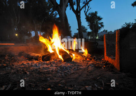 Kochen am offenen Lagerfeuer, ein Bügeleisen Topf auf einem Holzfeuer im Freien Stockfoto