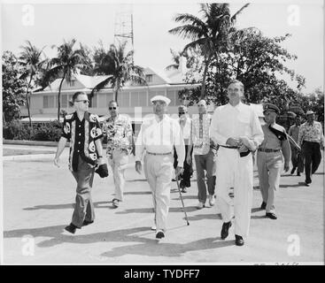 Foto von Präsident Truman auf seinem morgendlichen Spaziergang zum Strand während seines Urlaubs in Key West, Florida, von Eric Johnston, Leiter der wirtschaftlichen Stabilisierung Administration (flankiert, links) und W. Stuart Symington, Vorsitzender der National Security Resources Board (rechts), mit anderen Mitglieder seiner Entourage. Stockfoto