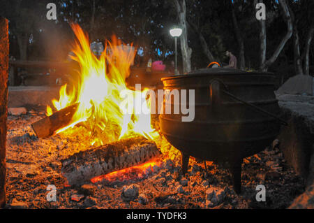 Kochen am offenen Lagerfeuer, ein Bügeleisen Topf auf einem Holzfeuer im Freien Stockfoto