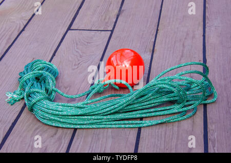 Meer gegen die Lieferung von der Anlegestelle an der Küste zu erleichtern. Eine Spule aus Dünne grüne Seil mit einem Kunststoff rote Kugel am Ende. Stockfoto