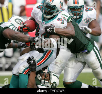 Miami Dolphins wide receiver Ricky Williams (34) ist durch die New York Jets, 18. Dezember 2005 An den Delphinen Stadion in Miami, FL in Angriff genommen. Die Miami Dolphins schlagen die New York Jets 24-20. (UPI Foto/Susan Knowles) Stockfoto