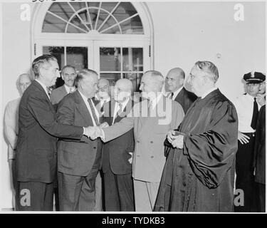 Foto von Präsident Truman die Hände schütteln mit Tom Clark im Rosengarten des Weißen Hauses, anlässlich der Clark's unter den Amtseid als Gerechtigkeit Mitarbeiter des U.S. Supreme Court, wie Außenminister Dean Acheson, Vice President Alben Barkley, Finanzminister John Snyder, Sprecher des Hauses Sam Rayburn, Verteidigungsminister Louis Johnson, Chief Justice Fred Vinson, und die anderen schauen zu. Stockfoto