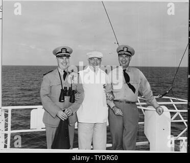 Foto von Präsident Truman mit Commander Donald J. MacDonald, kommandierender Offizier der Presidential Yacht, die U.S.S. WILLIAMSBURG (links) und Konteradmiral Robert Dennison, Naval Berater des Präsidenten, während Ferien Kreuzfahrt nach Key West, Florida. Stockfoto