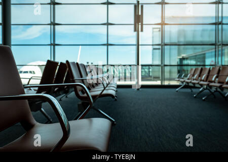 Die Sitze in der Abflughalle am Flughafen Terminal. Innenraum der Flughafen Terminal. Die Stühle im Abflugbereich auf internationaler Tor. Verkehr Stockfoto