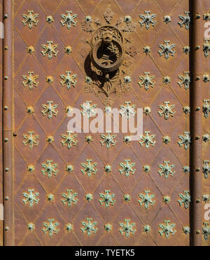 Alten rostigen kunstvoll mit Mustern und Nieten Tür eingerichtet. Stockfoto