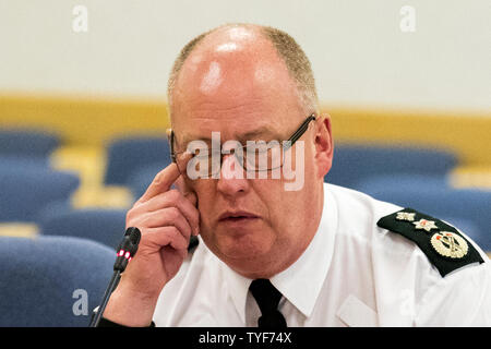 Ausgehende PSNI Polizeichef Sir George Hamilton reibt sein Auge während seiner letzten Tagung des Northern Ireland Policing Board in Belfast. Stockfoto