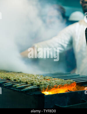 Mann Kebabs Grillen über Holzkohle Grill mit Rauch am Qureshi Kabab Ecke in Old Delhi Indien Stockfoto