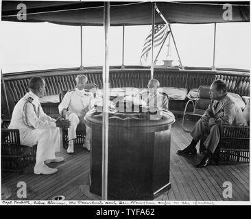 Foto während der Ferien Kreuzfahrt von Präsident Harry S. Truman nach Bermuda. Auf der fantail der US S. Williamsburg, L bis R: Kapitän James Foskett, Adm. Sir Irvine Glennie, Präsident Truman, und Gen. Harry Vaughan. Stockfoto