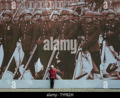 Ein Mädchen steht unter einem Plakat der sowjetischen Truppen im Zweiten Weltkrieg während einer Militärparade auf dem Roten Platz in Moskau am 9. Mai 2006. Heute Russland feiert den 61. Jahrestag des Sieges über Nazi-Deutschland. (UPI Foto/Anatoli Zhdanov) Stockfoto