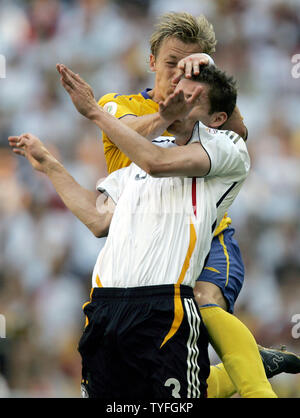 Schwedische Spieler Erik Edman (L) springt auf Arne Friedrich von Deutschland in der Welt Cup Fußball-Event in München, Deutschland, am 24. Juni 2006. Deutschland besiegt Schweden mit 2:0. (UPI Foto/Norbert Rzepka) Stockfoto