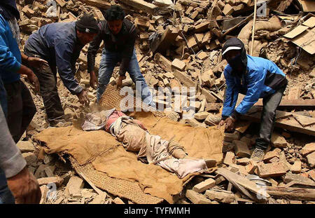 Eine nepalesische Rescue Team trägt den Körper eines Opfers aus den Trümmern eines Gebäudes, das nach einem Erdbeben in Bhaktapur, in der Nähe von Kathmandu, Nepal, 26. April 2015 brach erholt. Neue tremor Überlebenden hasten draußen nur 24 Stunden nach dem verheerenden Erdbeben der Stärke 7,9 erschüttert die Region erschüttert, die das Leben von mindestens 2500 Menschen, Nepalesische Beamte sagte. Foto von sanjog Manandhar/UPI Stockfoto