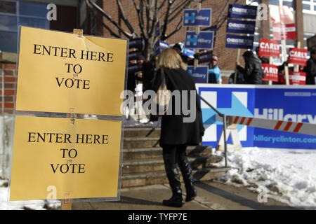 Eine Frau macht ihren Weg, vorbei an einer Schar von Aktivisten, wie sie in der präsidentenprimär Wahllokal an der Webster Volksschule in Manchester, New Hampshire Köpfe am 9. Februar 2016. Die New-Hampshire Präsidentenprimär ist das erste in der Nation und ist der Höhepunkt der Monate des Wahlkampfes durch einen großen Bereich der Präsidentschaftskandidaten. Foto von Matthew Healey/UPI Stockfoto