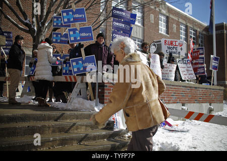 Eine Frau macht ihren Weg, vorbei an einer Schar von Aktivisten, wie sie in der präsidentenprimär Wahllokal an der Webster Volksschule in Manchester, New Hampshire Köpfe am 9. Februar 2016. Die New-Hampshire Präsidentenprimär ist das erste in der Nation und ist der Höhepunkt der Monate des Wahlkampfes durch einen großen Bereich der Präsidentschaftskandidaten. Foto von Matthew Healey/UPI Stockfoto