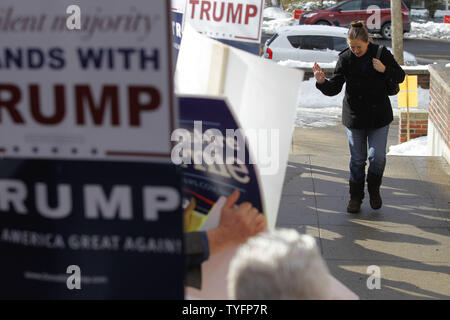 Eine Frau macht ihren Weg, vorbei an einer Schar von Aktivisten, wie sie in der präsidentenprimär Wahllokal an der Webster Volksschule in Manchester, New Hampshire Köpfe am 9. Februar 2016. Die New-Hampshire Präsidentenprimär ist das erste in der Nation und ist der Höhepunkt der Monate des Wahlkampfes durch einen großen Bereich der Präsidentschaftskandidaten. Foto von Matthew Healey/UPI Stockfoto