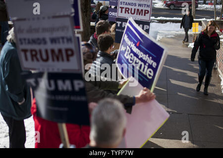 Eine Frau macht ihren Weg, vorbei an einer Schar von Aktivisten, wie sie in der präsidentenprimär Wahllokal an der Webster Volksschule in Manchester, New Hampshire Köpfe am 9. Februar 2016. Die New-Hampshire Präsidentenprimär ist das erste in der Nation und ist der Höhepunkt der Monate des Wahlkampfes durch einen großen Bereich der Präsidentschaftskandidaten. Foto von Matthew Healey/UPI Stockfoto