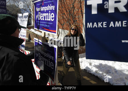 Eine Frau macht ihren Weg, vorbei an einer Schar von Aktivisten, wie sie in der präsidentenprimär Wahllokal an der Webster Volksschule in Manchester, New Hampshire Köpfe am 9. Februar 2016. Die New-Hampshire Präsidentenprimär ist das erste in der Nation und ist der Höhepunkt der Monate des Wahlkampfes durch einen großen Bereich der Präsidentschaftskandidaten. Foto von Matthew Healey/UPI Stockfoto