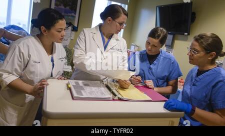 Von links, Lt Christine Johnson, Lt.Cmdr. Rozalyn Liebe, Lt Suzanne Papadakos, und Leutnant Jessica Dalrymple, Nachprüfungsverfahren folgenden postpartale Blutung Training am U.S. Naval Hospital Guam. Die Ausbildung soll Ärzte, Krankenschwestern und Krankenpfleger, die für die Vorbereitung, und Corpsmen für postpartale Blutung Veranstaltungen durch Unterrichten, wie quantitativ Blutverlust messen. Global, Nachsorge hemorraging ist die führende Ursache des Todes während der Schwangerschaft. Quantitative Messungen erstellen eine genauere Darstellung von, wie ernst das Bluten, was dazu führt, dass schneller und angemessener Behandlung. Stockfoto