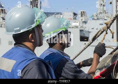 Meer (Nov. 6, 2016) Seaman Khanh Vo, Links, Uhren Petty Officer 2nd class Durell Graham rig die Spanne Draht auf der Arleigh-Burke-Klasse geführte Anti-raketen-Zerstörer USS Curtis Wilbur (DDG54) während einer laufenden Replenishment (Unrep) mit dem Militär Sealift Command (MSC) Dry Cargo und Munition Ship USNS Charles Drew (T-AKE-10). Curtis Wilbur ist auf Patrouille im philippinischen Meer Unterstützung der Sicherheit und Stabilität in der Indo-Asia-Pazifik-Region. Stockfoto