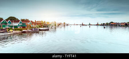 Wunderschöne Aussicht, fantastische Landschaft von einem Fluss mit Windmühlen auf seiner Bank, berühmte Sehenswürdigkeiten, Zaanse Schans, Holland, Stockfoto