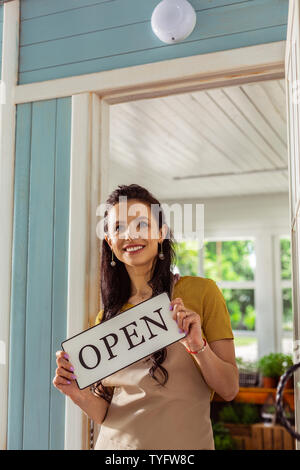 Glückliche Frau, die auf der Veranda Ihrer Shop. Stockfoto