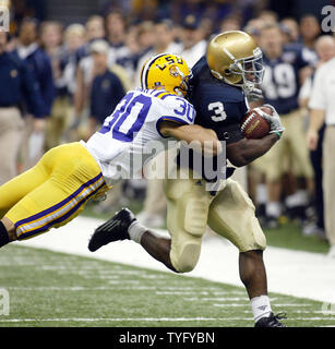 Notre Dame zurück laufen Darius Walker (3) Holt die 5-Yards über der linken Seite der Zeile während 2. Quartal Maßnahmen während der Allstate Sugar Bowl in New Orleans am 3. Januar 2007. Die Verteidigung auf der Spiel ist der LSU LaRon Landry (30). Der Sugar Bowl zurück zu Superdome dieses Jahr, nachdem der Hurrikan Katrina im vergangenen Jahr, als das Spiel war im Georgia Dome gespielt verdrängt wird. (UPI Foto/A.J. Sisco) Stockfoto