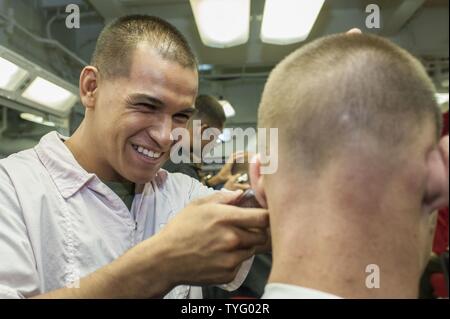 Ozean (Nov. 8, 2016) Lance Cpl. Alejandro Collazo, aus Orange County, Kalifornien, schneidet die Haare in der Friseur an Bord der Amphibisches Schiff USS Makin Island (LHD8). Makin Island, das Flaggschiff der Makin Island Amphibious Ready-Gruppe, die in den USA 7 Flotte Bereich für Maßnahmen zur Erhöhung der Sicherheit und der Stabilität in der Indo-Asia-Pazifik-Region. Stockfoto