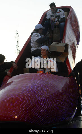 In einem riesigen Schuh float eingebettet, von unten, New Orleans Saints Field Goal Kicker Garrett Hartley, börsenspekulant Thomas Morstead und lange Snapper Jason Kyle Perlen zu Heiligen fans Februar 9, 2010 werfen, während einer Parade in New Orleans die Heiligen Super Bowl Sieg zu feiern. Die hochhackigen Schuh Schwimmer wurde von der kommenden Frauen Karnevalsumzug geborgt, Musen. UPI/A.J. Sisco Stockfoto