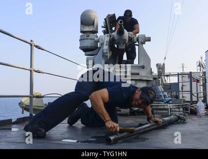 Golf von Aden (Nov. 7, 2013) Seaman Nickolas Rounceville, Vordergrund, und Petty Officer 3rd Class Juan Rivera nach der Brand Wartungsarbeiten an einem MK-38 25mm machine gun System an Bord der Amphibischen dock Landung Schiff USS Langley (LSD 41). Whidbey Island ist mit dem Wasp Amphibious Ready Gruppe implementiert Maritime Security Operations und Theater Sicherheit Zusammenarbeit in den USA 5 Flotte Bereich der Aktivitäten zu unterstützen. Stockfoto