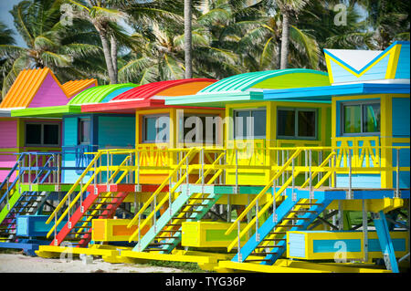 Bunte szenische Morgen Blick auf die hell gestrichenen Rettungstürme mit Kokosnuss Palmen auf der Promenade in South Beach in Miami, Florida, USA Stockfoto