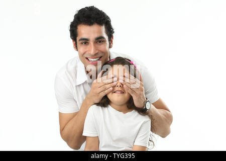 Porträt eines Mannes, der die Augen seiner Tochter von hinten bedeckt Stockfoto