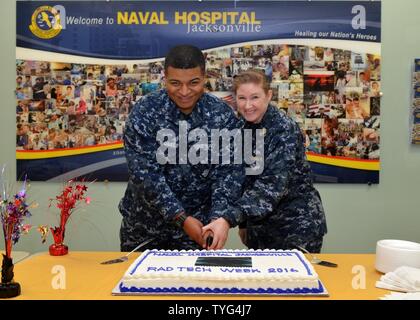 JACKSONVILLE, Fla. (Nov. 7, 2016) - Petty Officer 3rd Class Pierre Jean-Gilles (links) und Senior Chief Petty Officer Michelle Hopson, Vertreter der meisten Junior und Senior in der Radiologie am Naval Hospital (NH) Jacksonville, schneiden Sie die zeremoniellen Kuchen auf nationaler Bildgebende Woche feiern. Sein 75-jähriges Bestehen in diesem Jahr feiern, NH Jacksonville's Priority seit seiner Gründung im Jahre 1941 ist die Helden der Nation und ihre Familien zu heilen. Stockfoto