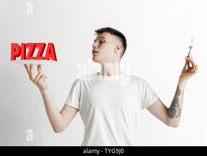 Mann im Hemd mit dem Folk isoliert auf Weiss. Männliches Modell Holding eine Platte mit Buchstaben des Wortes Pizza. Sie gesunde Ernährung, Ernährung, biologische Ernährung und Natur freundlich Lebensstil. Stockfoto