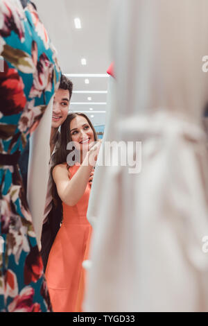 Frau und Mann auf der Suche nach Kleider auf eine Schaufensterpuppe in Fashion Store