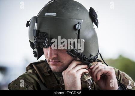 Staff Sgt. Jeffrey Pratt, Flight Engineer mit der 8 Special Operations Squadron, zieht seinen Helm vor einem Flug am Hurlburt Field, Fla., Nov. 8, 2016. Das bodenpersonal mit der 8. SOS Verhalten routine Ausbildung Flüge ihre Bereitschaft, globale spezielle Operationen auszuführen, zu gewährleisten. Stockfoto