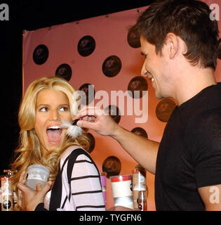 Sängerin Jessica Simpson Ehemann Nick Lachey gilt spielerisch einige Hautpflege zu seiner Frau während der Markteinführung ihres neuen Skin Care Product Line 'Dessert' am 31.01.13, 2004 in New York. (UPI/Ezio Petersen) Stockfoto