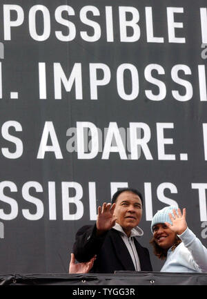 Boxlegende Muhammad Ali und seine Tochter IBA Supermittelgewicht Boxing champion Laila Ali Welle an, zu den Volksmengen Jan. 5, 2004, nachdem Sie eine Wallscape Adidas ad in Harlem, New York vorgestellt. (UPI/Ezio Petersen) Stockfoto