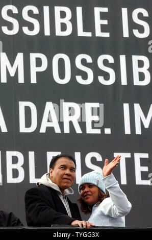 Boxlegende Muhammad Ali und seine Tochter IBA Supermittelgewicht Boxing champion Laila Ali Welle an, zu den Volksmengen Jan. 5, 2004, nachdem Sie eine Wallscape Adidas ad in Harlem, New York vorgestellt. (UPI/Ezio Petersen) Stockfoto