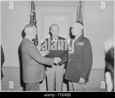 Präsident Truman schüttelt Hände mit General Omar Bradley, der gerade als Stabschef der US-Armee vereidigt wurde. General Dwight Eisenhower ist in der Mitte. Die Zeremonie fand im Pentagon. Stockfoto