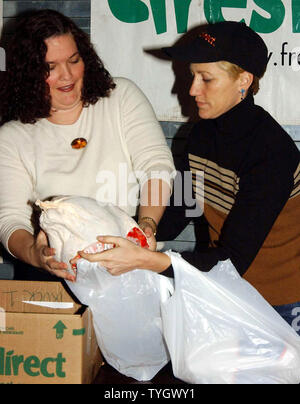 Schauspielerin Edie Falco, Star der TV-Serie "Die Sopranos" (rechts) Clowns, Futtermittel, Plastiktüten und Hände, die einige der 600 Thanksgiving Truthähne gespendet von FreshDirect an November 23, 2004 auf die Yorkville gemeinsame Speisekammer in New York. (UPI Foto/Ezio Petersen) Stockfoto