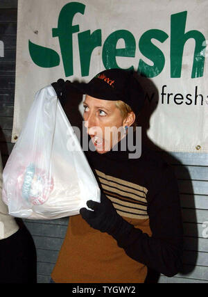 Schauspielerin Edie Falco, Star der TV-Serie "Die Sopranos" Clowns, Futtermittel, Plastiktüten und Hände, die einige der 600 Thanksgiving Truthähne gespendet von FreshDirect an November 23, 2004 auf die Yorkville gemeinsame Speisekammer in New York. (UPI Foto/Ezio Petersen) Stockfoto