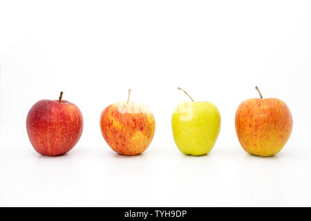 Vier Äpfel in einer Reihe mit drei rote Äpfel und ein grüner Apfel Stockfoto