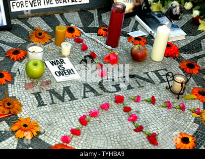 Blumen, Kerzen und Erinnerungsstücke sind auf dem "Imagine" Mosaik von Fans an Strawberry Fields, als Hunderte von Fans Hommage an John Lennon, der vor 25 Jahren am 8. Dezember 2005 in New York City ermordet wurde, bezahlen. 1980 Der ehemalige Beatle wurde von Mark David Chapman vor dem Dakota Apartment Gebäude, wo er über die Straße vom Park lebten, getötet. (UPI Foto/Monika Graff) Stockfoto