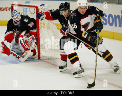 Atlanta Thrashers' Bobby Holik, rechts, hält den Puck vor New York Rangers' Tom Poti, Mitte, als Ranger goalie Henrik Lundqvist seine Wache hält, der während des ersten Anwendungszeitraums der Spielen im Madison Square Garden am 12. März 2006 in New York City. (UPI Foto/Monika Graff) Stockfoto