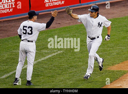 New York Yankees (18) Johnny Damon klatscht die Hand der Dritten base Trainer Larry Bowa, nachdem er einen home run in der Unterseite des ersten Inning in Yankees Stadion in New York City am 8. Juni 2006. Die New York Yankees host die Boston Red Sox. (UPI Foto/John angelillo) Stockfoto