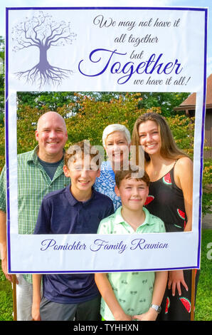 Drei Generationen darstellen in eine kluge Cut-out Bilderrahmen für eine Familie Portrait bei einer amerikanischen Familie Wiedervereinigung an einem Sommertag in Connecticut, USA. Die älteren Teilnehmer an einem typischen Familientreffen sind in der Regel die Großeltern, Eltern, Geschwister und Cousins, während die Jüngsten zweiten, dritten oder vierten Cousins. Einige Familientreffen sind in regelmäßigen jährlichen Abständen statt, oder Sie können besondere Anlässe jeden 5. oder 10. oder so. Es ist immer eine Zeit, die neuesten Mitglieder der erweiterten Familie zu treffen und zu teilen Geschichten, Fotos und Essen. Stockfoto